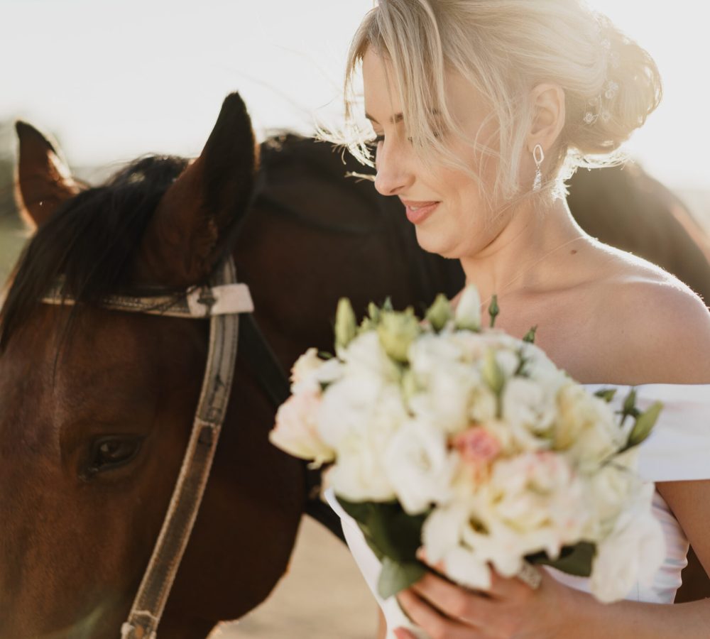 Portrait of a beautiful bride standing with horse